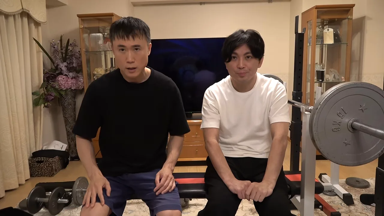 筋トレ器具の前に座っている二人の男性の様子。