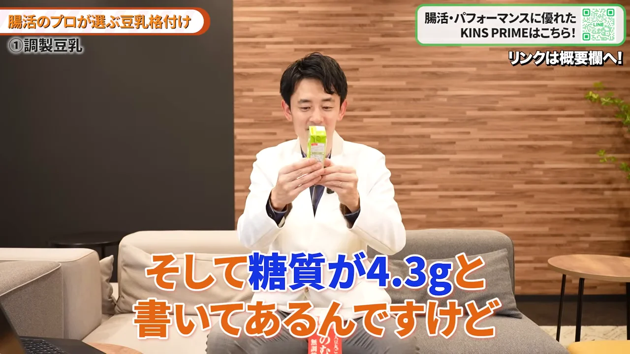 白衣姿の男性が両手で小さな紙パックを持ち、記載内容を確認している。