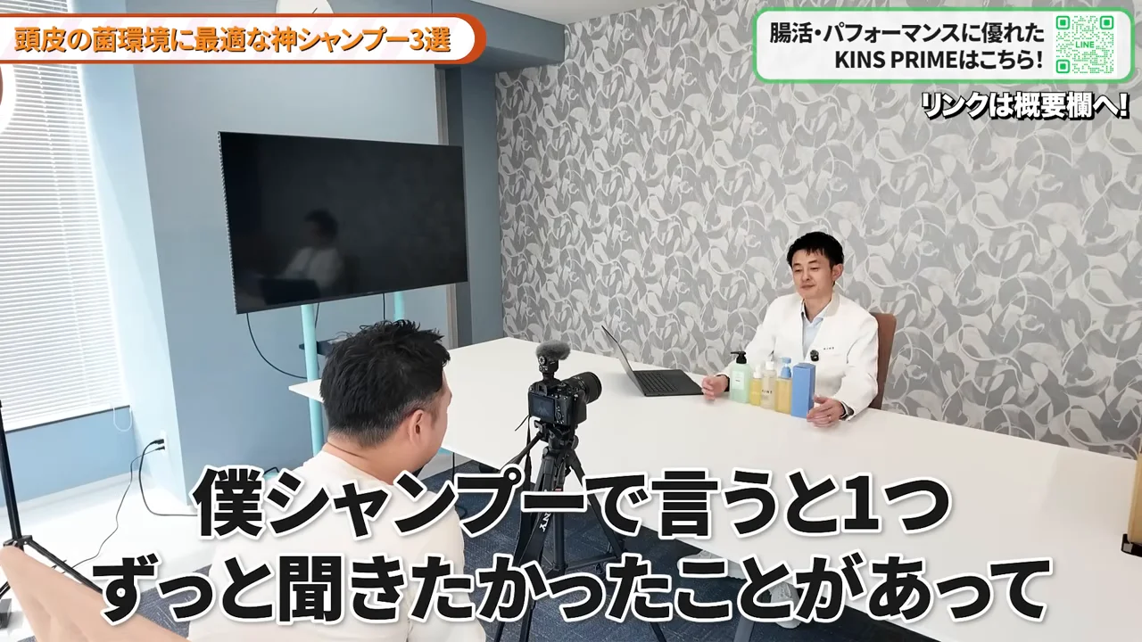カメラ越しに白衣の男性がテーブルを挟んで対話しているスタジオの様子。