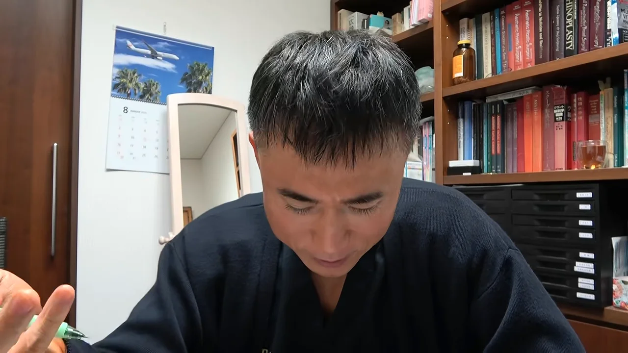 視線を落としながら手元を動かして話す男性。