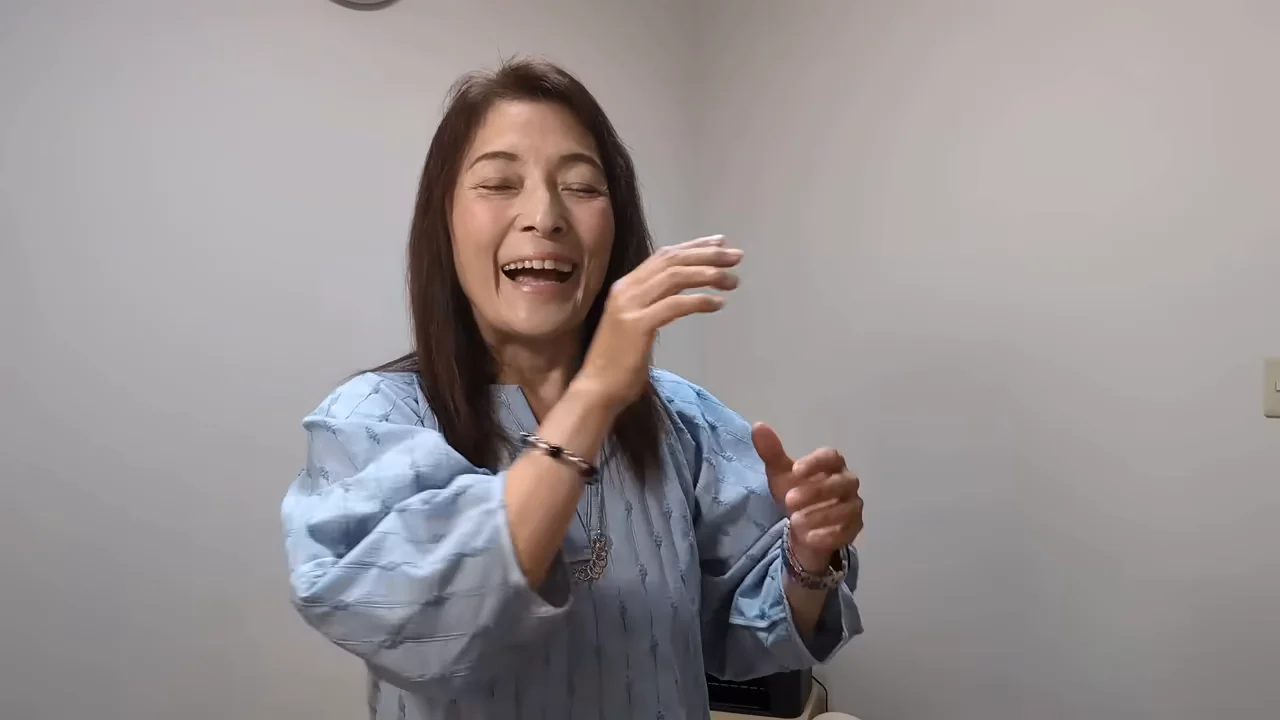 女性が手振りをつけて笑顔で話している様子。