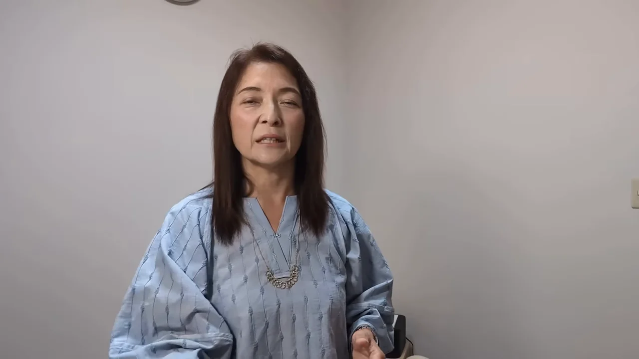 女性が正面を向いて落ち着いた表情で話している様子。