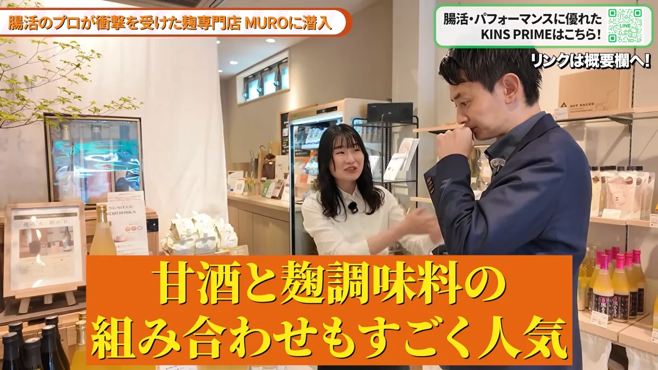 商品が並ぶ店内で女性スタッフと男性が会話している様子。