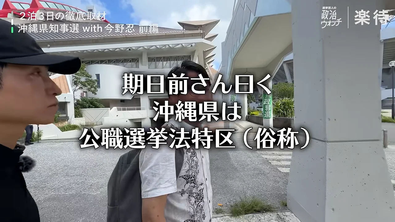 建物の前で男性2人が屋外に立ち、話している様子。