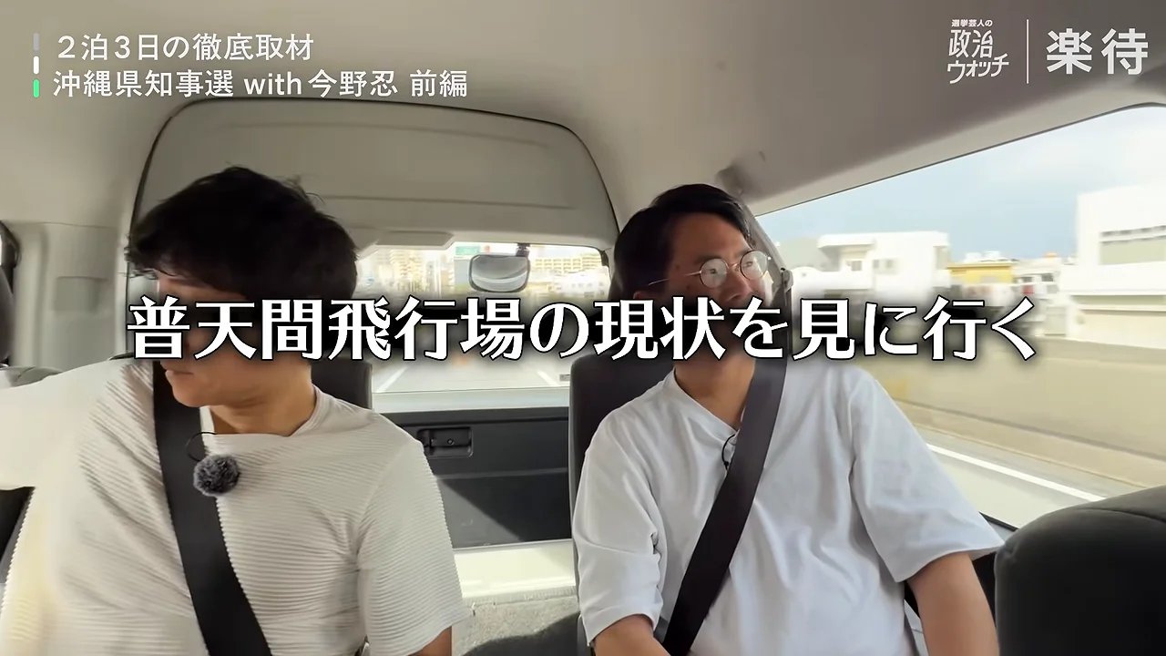 車内の座席に座り、シートベルトを着けた2人の男性の姿。