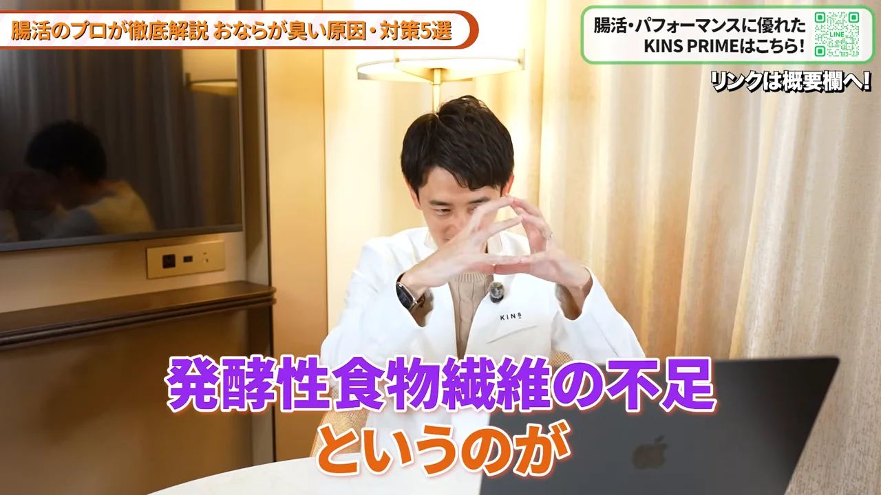 白衣を着た男性が両手で形を作りながら説明している様子。