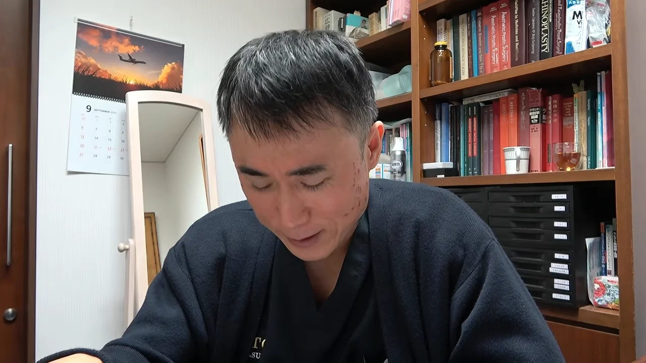 部屋の中で下を向いて語りかける男性の様子。