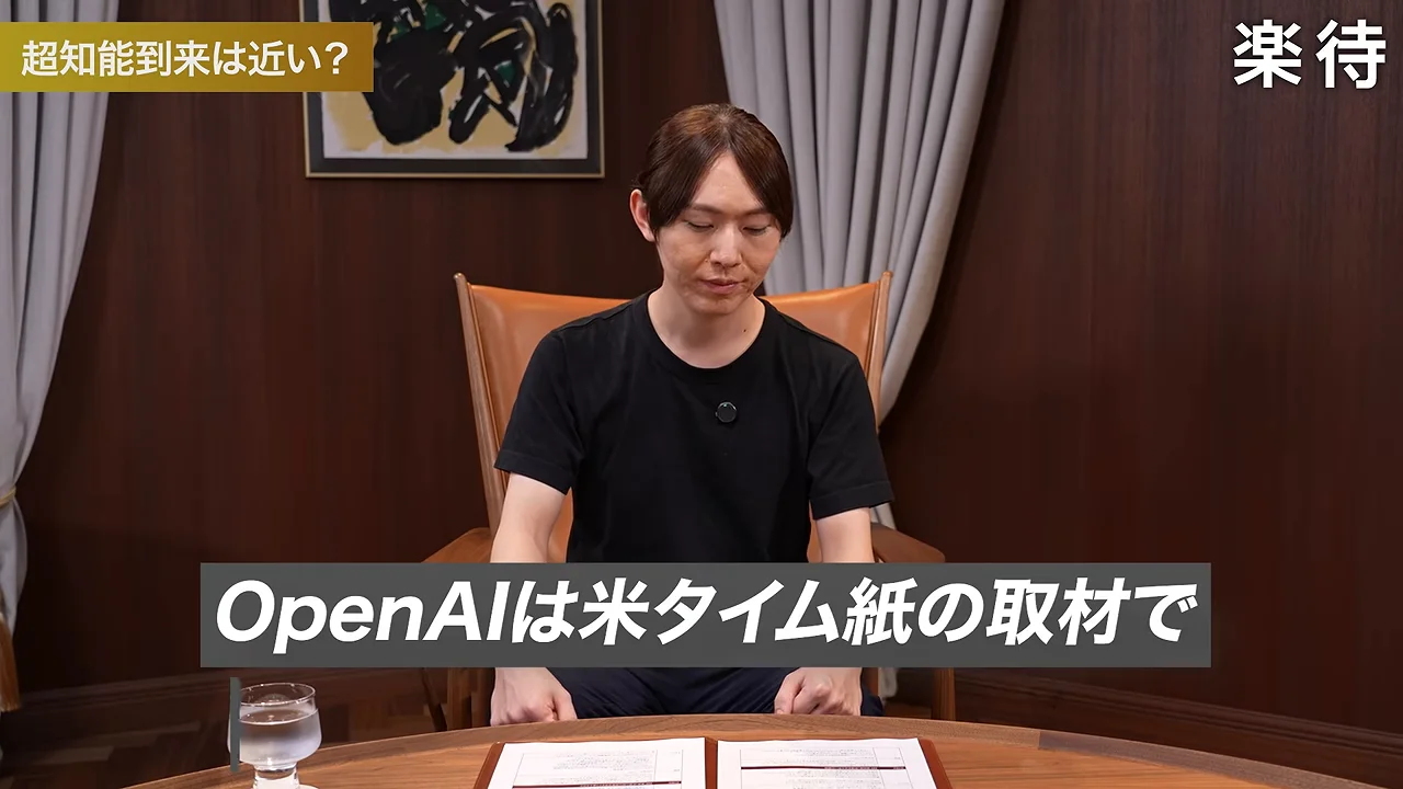 テーブルの前に座った人物が手元を見つめている様子。
