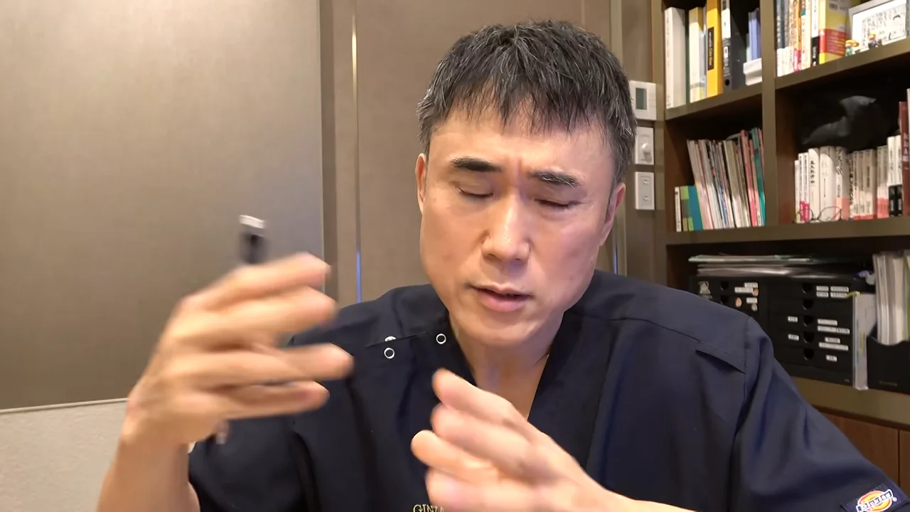 男性がペンを持ちながら両手で身振り手振りをして語っている様子。