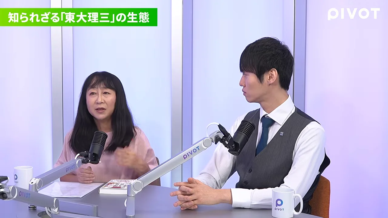 マイクが設置されたスタジオのテーブル席で並んで座る女性と男性。