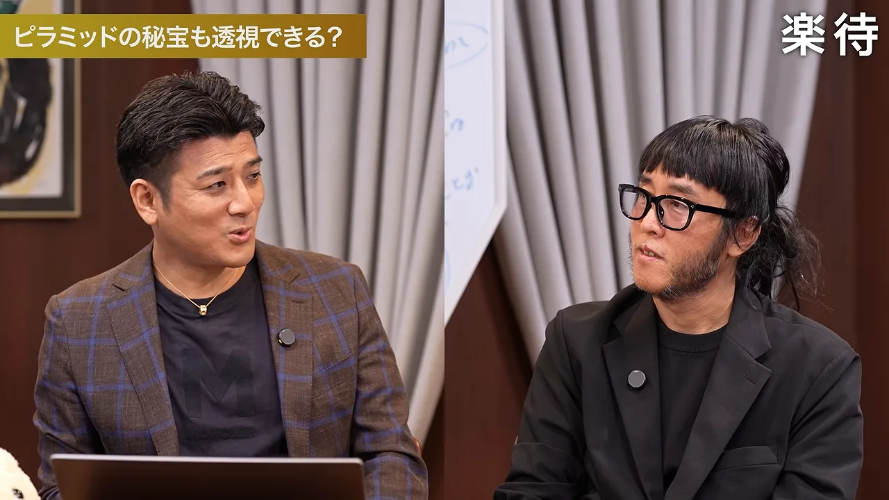 スタジオで、ジャケット姿の男性二人が向かい合って座っている。